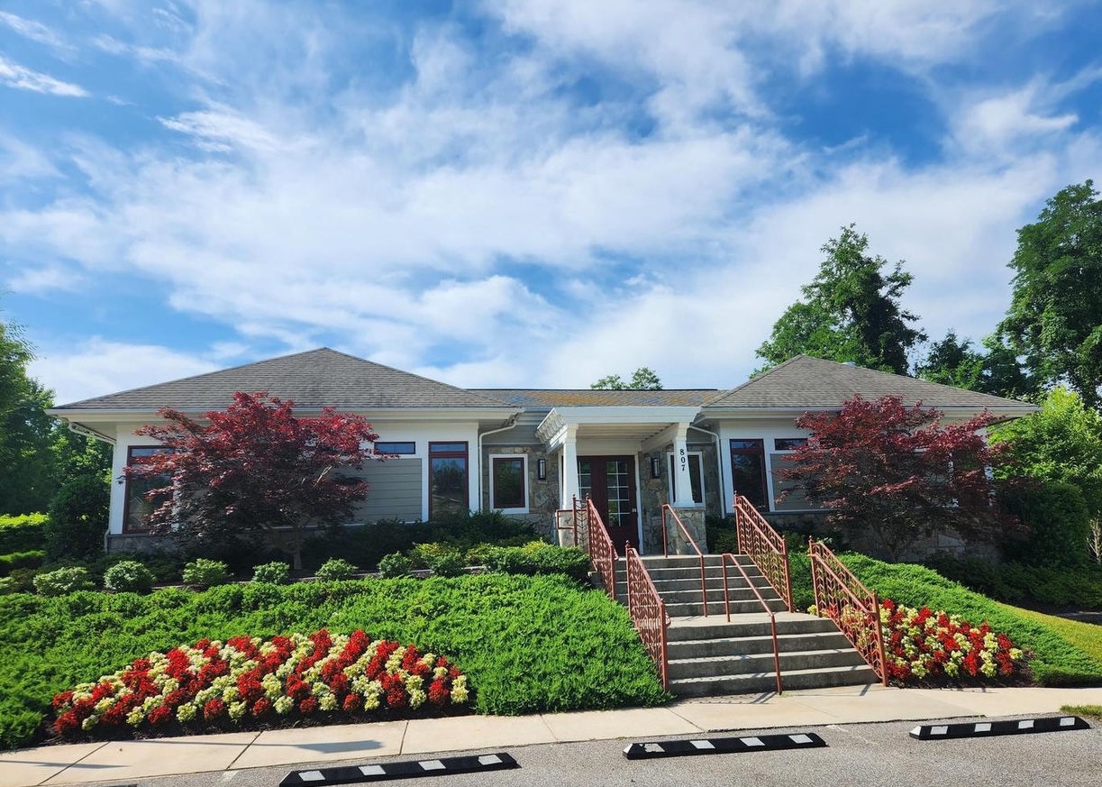The Wilson's Grove clubhouse at 807 Sebastian Lane, with red maples and flower beds out front